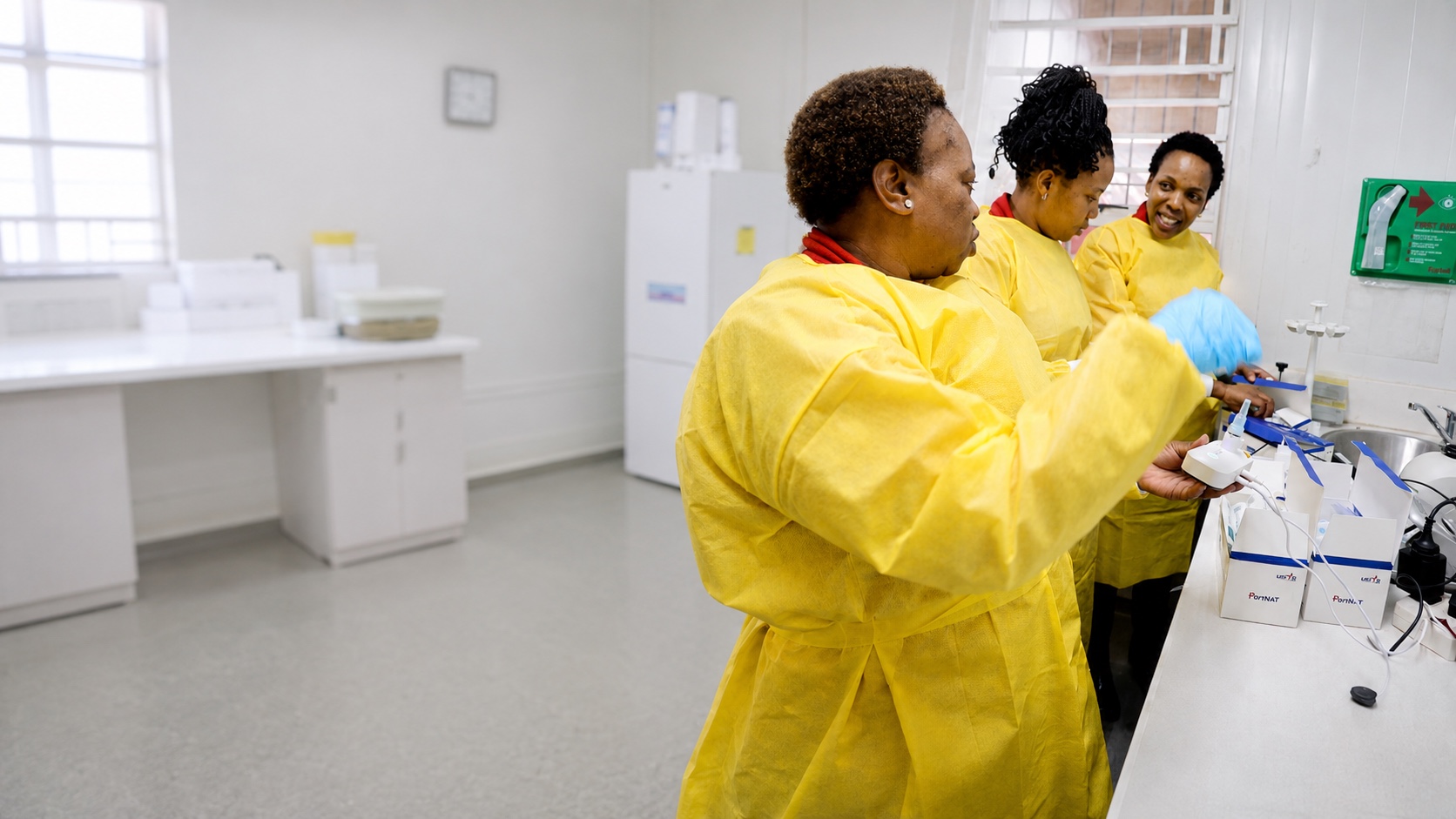 Aurum laboratory staff working with a PortNAT point-of-care TB diagnostics device